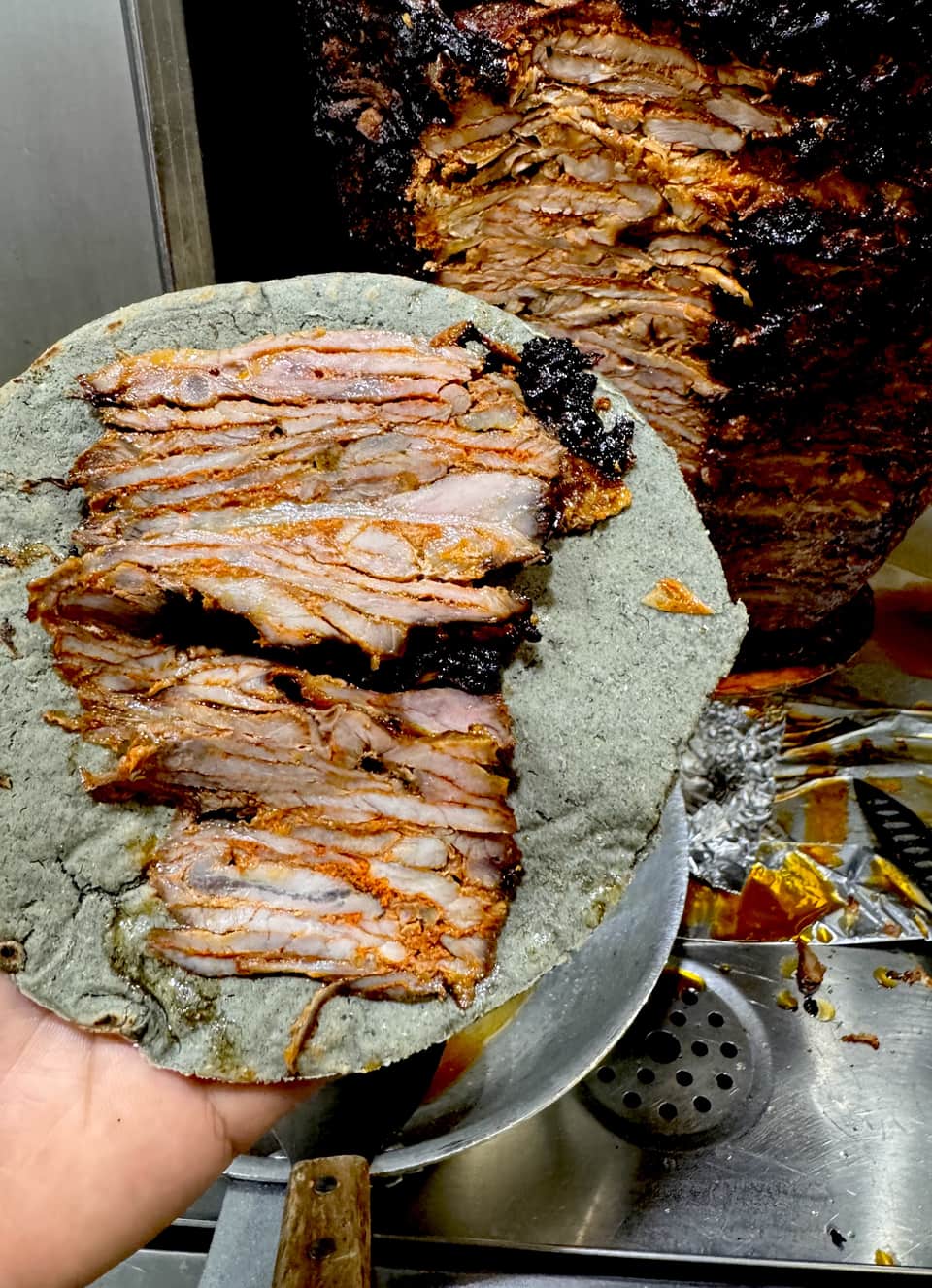 Al pastor being carved fresh from the trompo